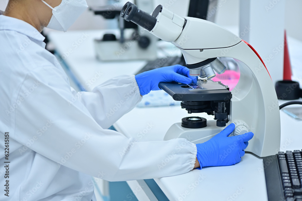 Medical Science Laboratory: Portrait of a scientist looking under a microscope without analyzing a test sample. Ambitious young biotechnologist working with advanced equipment. Medical Science Laboratory: Portrait of a scientist looking under a microscope without analyzing a test sample. Ambitious young biotechnologist working with advanced equipment.
