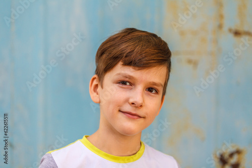 caucasian boy nine years old looking at the camera standing on the street. close-up