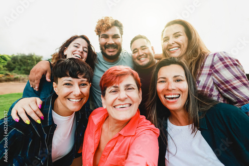 Multi generational people taking selfie outside - Happy group of friends having fun together outdoor at park city - Friendship and diversity community concept photo