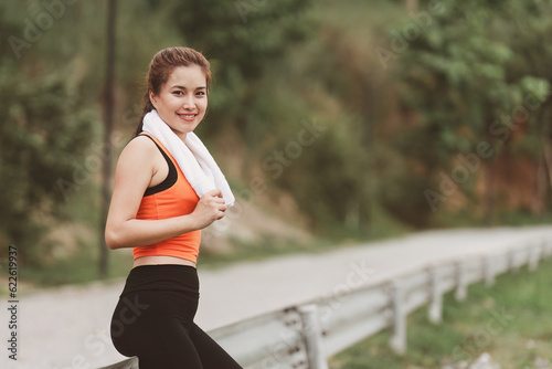 Healthy Asian woman is warm up before jogging. Fitness girl running. Female exercising at outdoor park