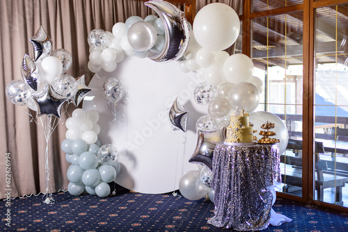 White photo zone  in shape of circle  with balloons and cake on birthday party.