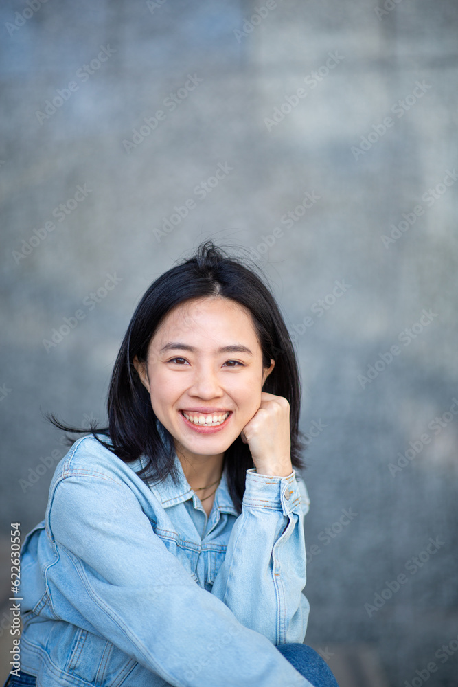 smiling young chinese woman with hand to chin pose smiling young chinese woman with hand to chin pose