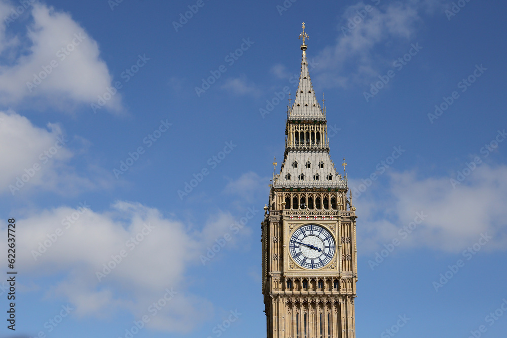 Big Ben Clock Tower in London, UK in a day with white clouds and blue sky.