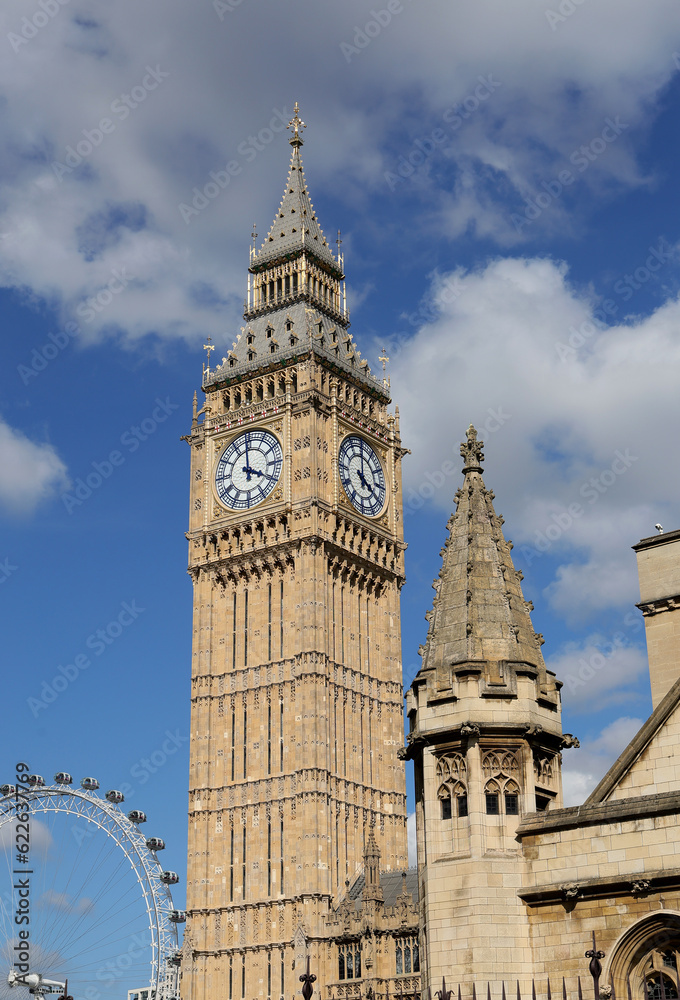 Big Ben Clock Tower in London,houses of parliament and London eye, UK, in a day with white clouds and blue sky.