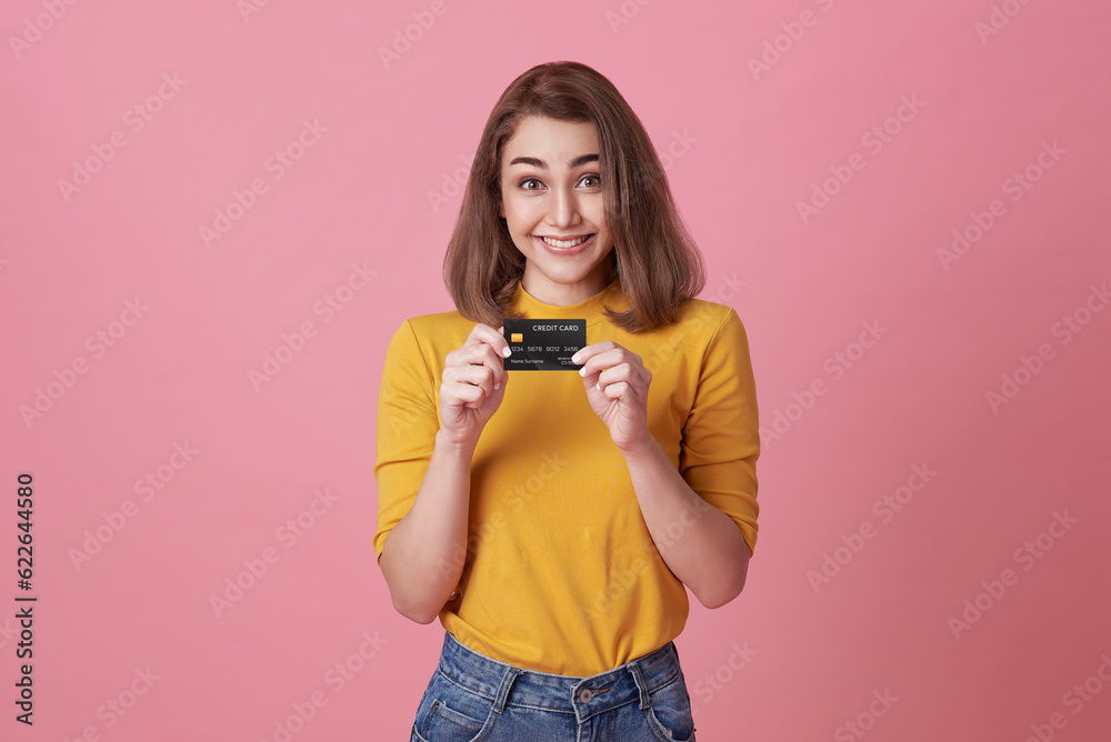 Cheerful happy woman enjoying showing credit card isolated on pink background. Cheerful happy woman enjoying showing credit card isolated on pink background.