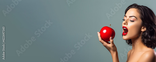 Beautiful young woman holding a red apple - symbolic of sin and temptation banner