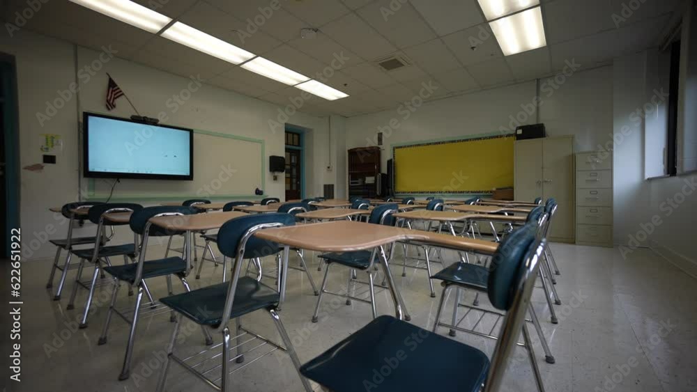 Camera booms up from floor to the ceiling showing an empty school classroom with smart board, white board, desks, chairs, US flag. Camera booms up from floor to the ceiling showing an empty school classroom with smart board, white board, desks, chairs, US flag.