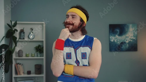 Ginger retro hipster sportsman standing in confident pose training at home ans whosing an OK sign to the camera. photo