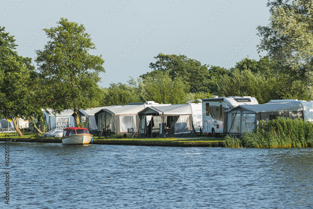 camping for motorhomes with large tents on the shore of a lake in the Netherlands