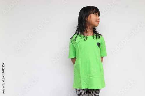 A smiling friendly kid girl looking at something to her sideway