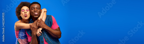 Fotografia Young african american best friends in bright and trendy summer outfits hugging