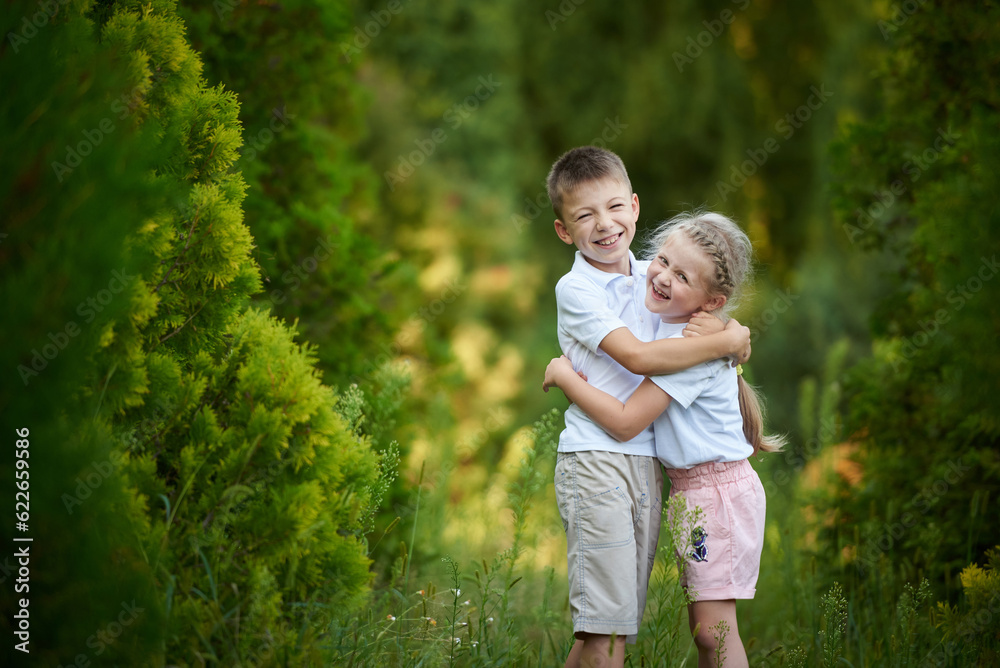 Fototapeta premium Little brother and sister hugging and happy together in the park