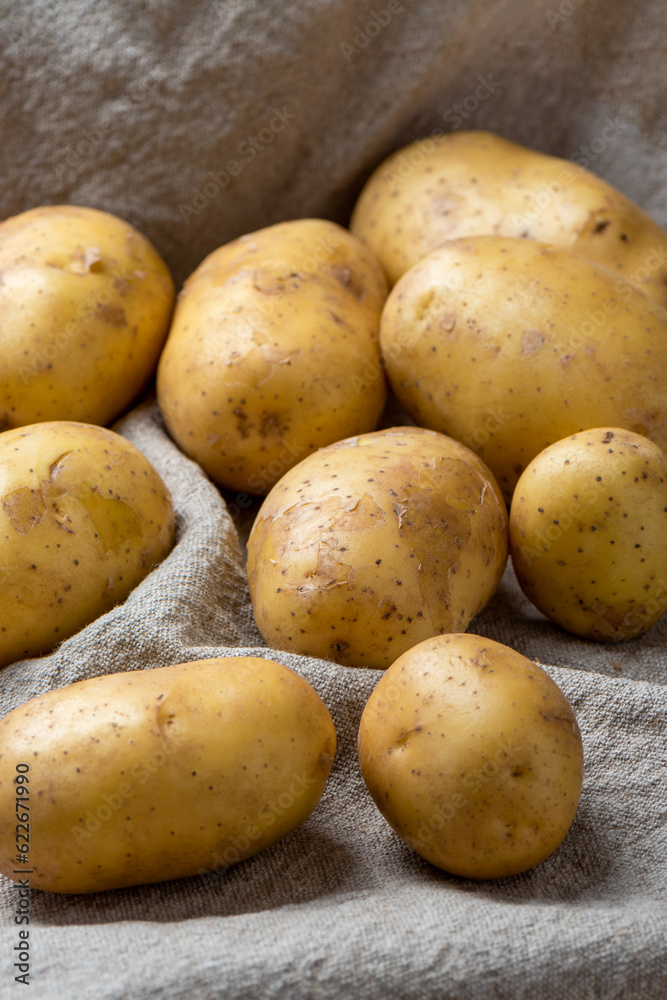 Washed potato tubers of a new crop on a coarse burlap fabric. Washed potato tubers of a new crop on a coarse burlap fabric.