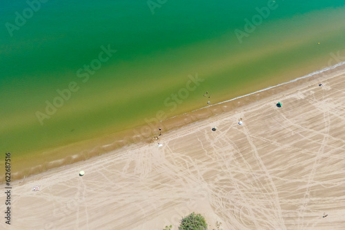 Aerial view of people with parasol on Plaja de Riumar, a beach in Delta de l'Ebre national park, Deltebre, Tarragona, Spain. photo