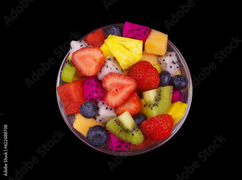 Top view of bowl with fruit salad isolated on black background