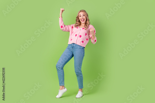 Full body photo of overjoyed satisfied glad pretty lady raise fists triumph rejoice isolated on green color background