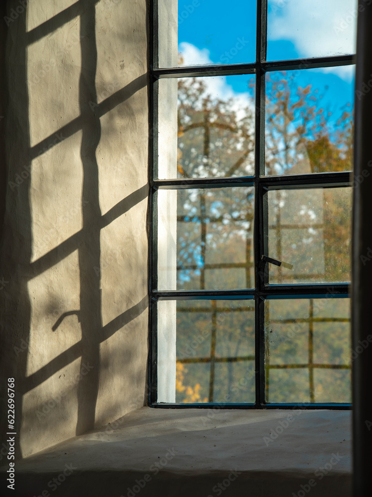 Close-up of a lattice window. Shadows on wall. Sunny autumn day. Close-up of a lattice window. Shadows on wall. Sunny autumn day.