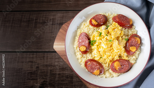 couscous with scrambled eggs and pepperoni sausage on dark wood and fabric ( cuzcuz )