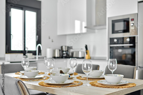 Dinnerware served on dining table in modern kitchen