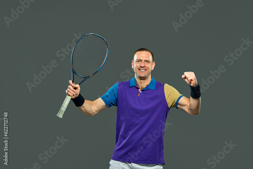 Man, professional tennis player posing with racket isolated over grey background. Winner, champion. Concept of professional sport, action and motion, health., strength, competition, ad © master1305