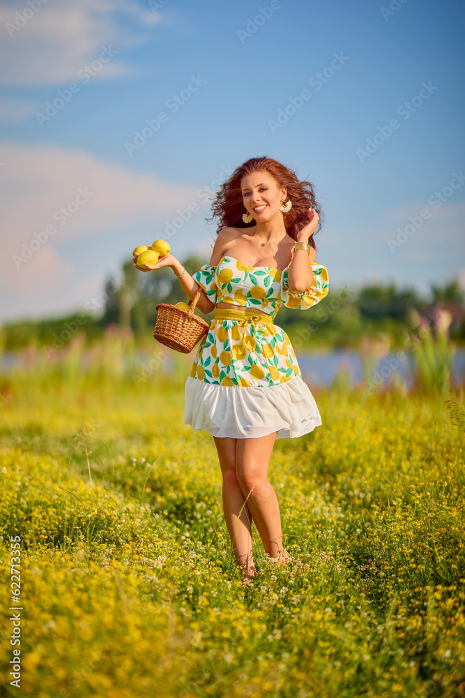 portrait of a beautiful woman with lemons on a meadow near a lake. portrait of a beautiful woman with lemons on a meadow near a lake.