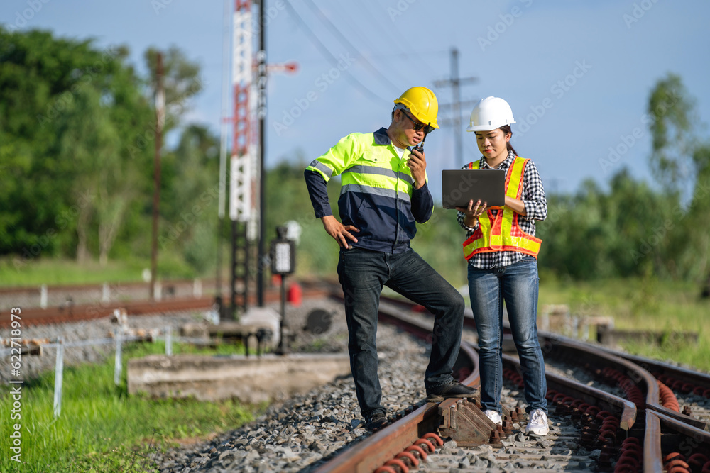 Architects and engineers wear safety suits and helmets to work. standing to inspect the tracks to plan for maintenance. Architects and engineers wear safety suits and helmets to work. standing to inspect the tracks to plan for maintenance.
