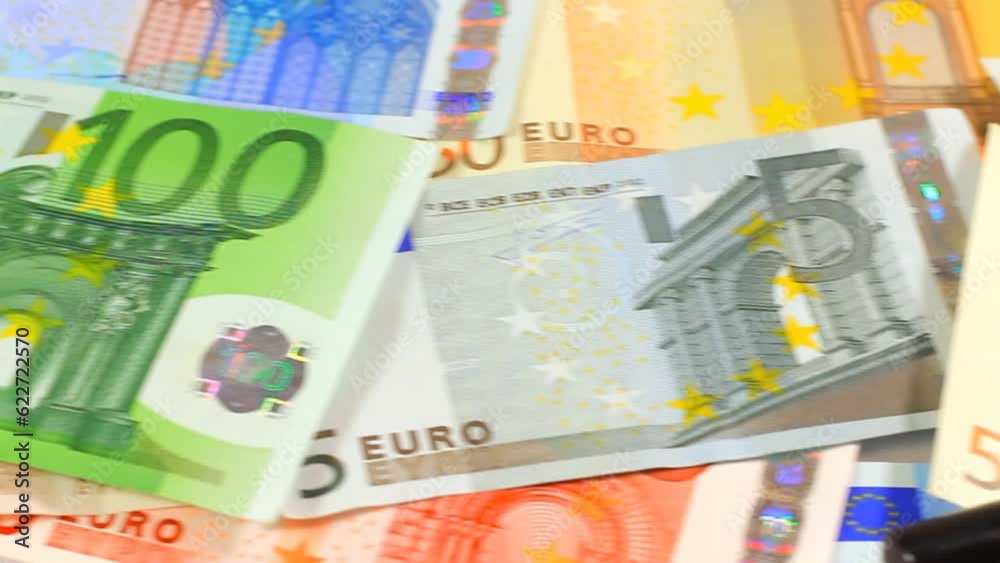 Camera pans to magnifying loupe over money. Euro paper notes passing in front of camera. Perfect for any financial, commerce, treasury or banking video needs.
Camera pans to magnifying loupe over money. Euro paper notes passing in front of camera. Perfect for any financial, commerce, treasury or banking video needs.