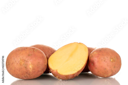 Several whole pink  raw potatoes and half  macro  isolated on white background.