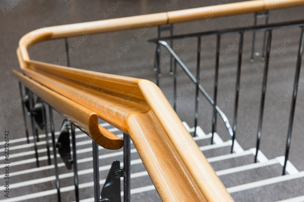 Curved wooden handrail close-up photo with selective soft focus