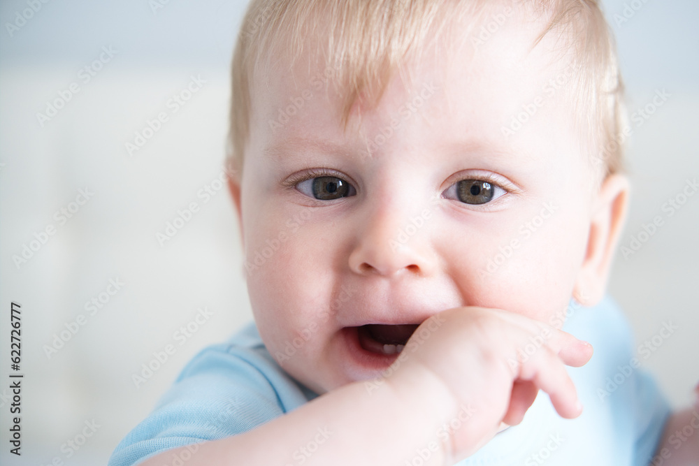 close up child with his fingers in his mouth, his teeth are teething. Baby teeth grow