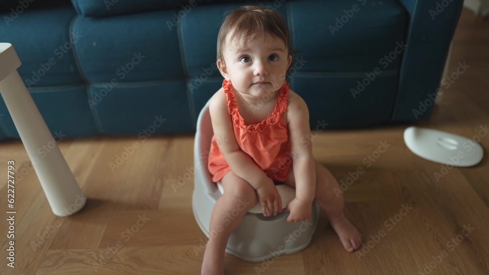baby sitting on the potty. Toddler baby girl goes to the toilet sits on