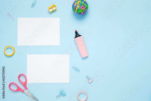 Mockup white papers and set of stationery for work and study on blue background. Back to school. Top view, flat lay, copy space