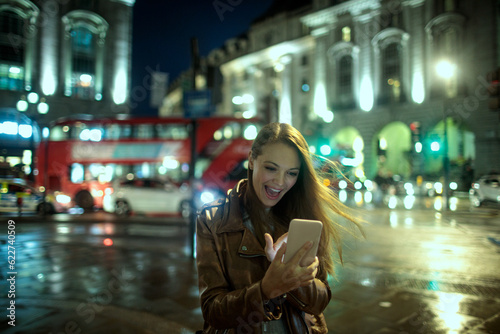 Young woman using a smart phone while walking in the city london