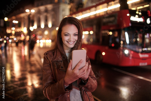 Young woman using a smart phone while walking in the city london