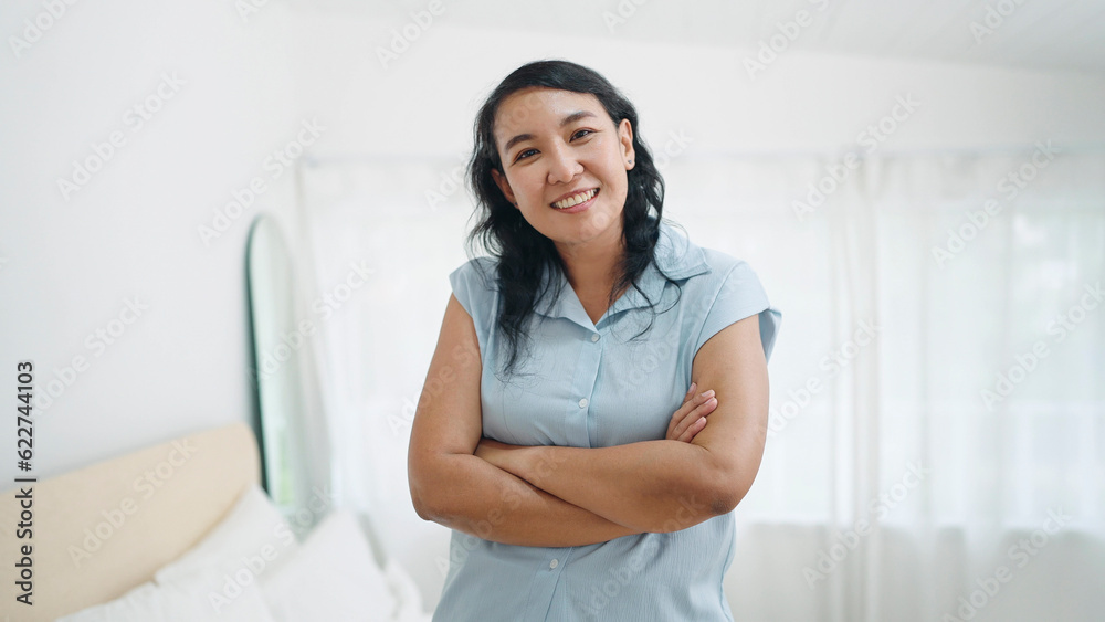 Portrait of happy adult asian woman standing with arms crossed, smiling to camera Portrait of happy adult asian woman standing with arms crossed, smiling to camera