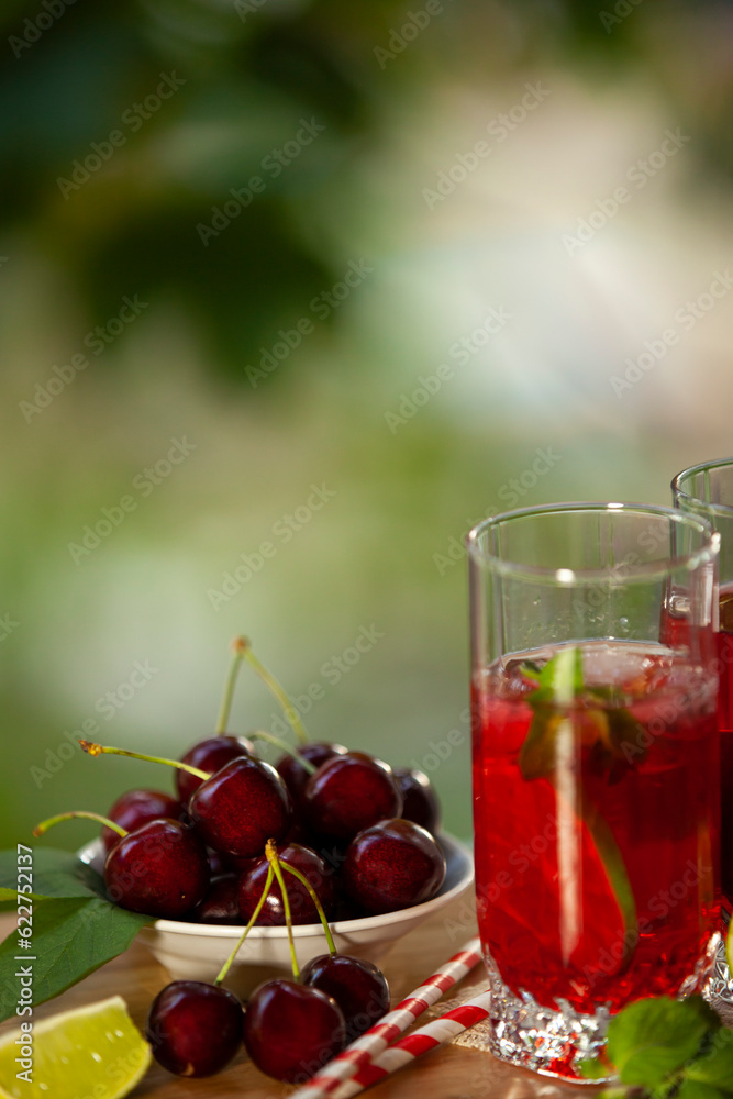 Cherry lemonade with ice and lime in glasses. Summertime cool drink.