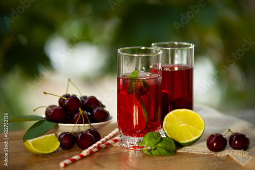 Obraz na płótnie Cherry lemonade with ice and lime in glasses. Summertime cool drink. w salonie