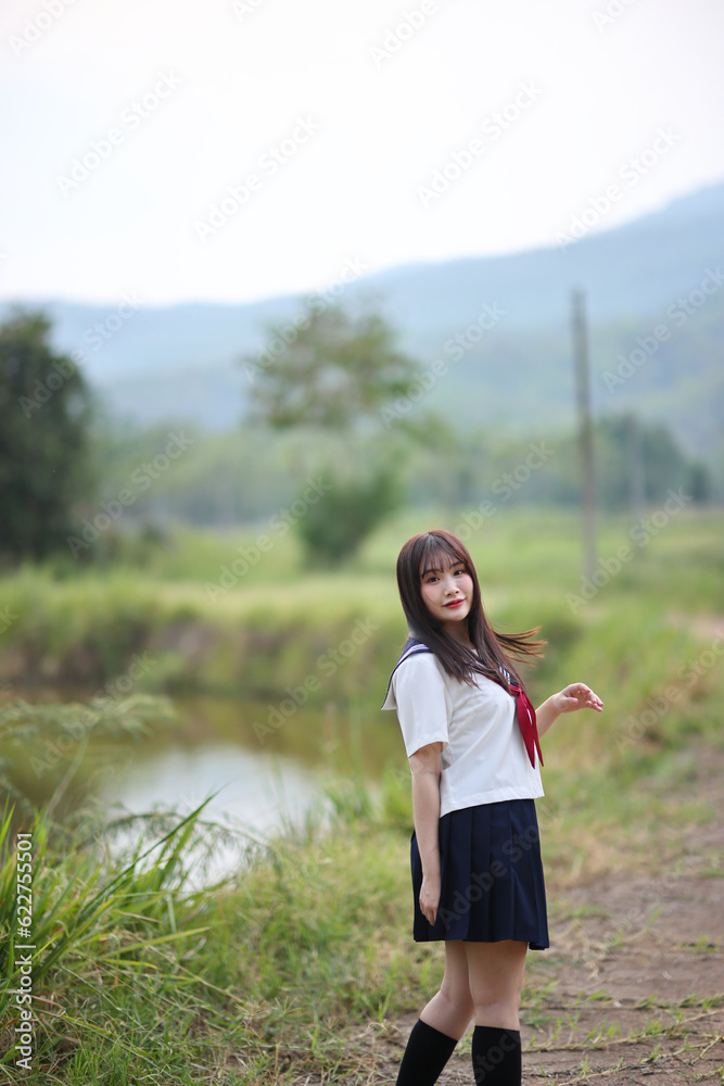 Japanese high school student looking on countryside background Japanese high school student looking on countryside background