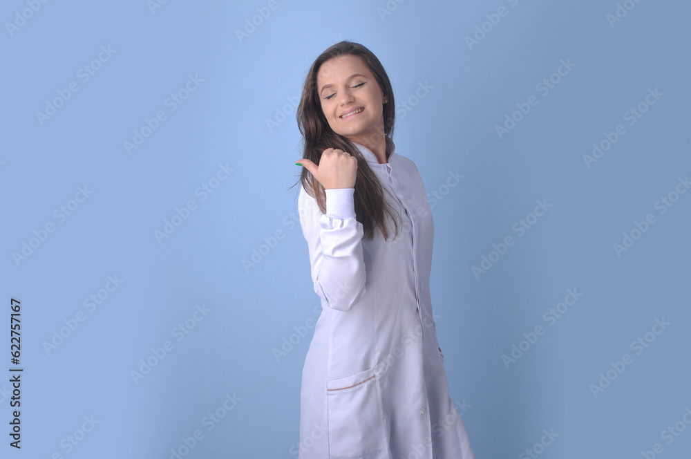 médica jovem sorridente usando uniforme branco em fundo azul, expressão feliz apontando para anúncio ou promoção médica jovem sorridente usando uniforme branco em fundo azul, expressão feliz apontando para anúncio ou promoção