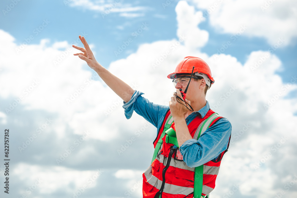 Elegant engineer holding a walkie talkies to working in determined and has a vision like a leader, Discussion and coordination between departments about problem solving, blue collar concept Elegant engineer holding a walkie talkies to working in determined and has a vision like a leader, Discussion and coordination between departments about problem solving, blue collar concept
