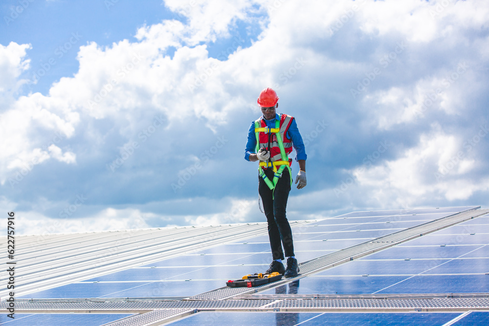 Engineer technician using laptop checking and operating system on rooftop of solar cell farm power plant, Renewable energy source for electricity and power, Solar cell maintenance concept Engineer technician using laptop checking and operating system on rooftop of solar cell farm power plant, Renewable energy source for electricity and power, Solar cell maintenance concept