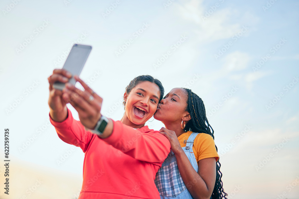 Selfie, kiss and friends posing together outdoor during summer to update a profile picture or status. Photograph, love and bonding with excited young women posting to social media while in nature Selfie, kiss and friends posing together outdoor during summer to update a profile picture or status. Photograph, love and bonding with excited young women posting to social media while in nature