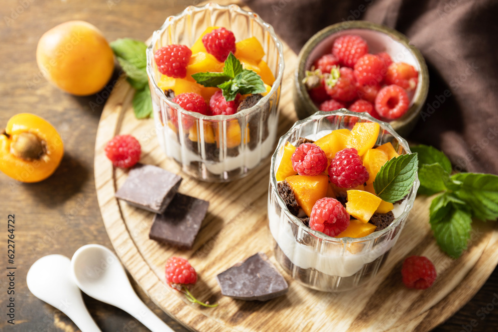 Triffle of chocolate biscuit with yogurt and fresh berries and fruits. Two portioned glass parfafait dessert. Summer healthy diet breakfast, snack concept. Triffle of chocolate biscuit with yogurt and fresh berries and fruits. Two portioned glass parfafait dessert. Summer healthy diet breakfast, snack concept.