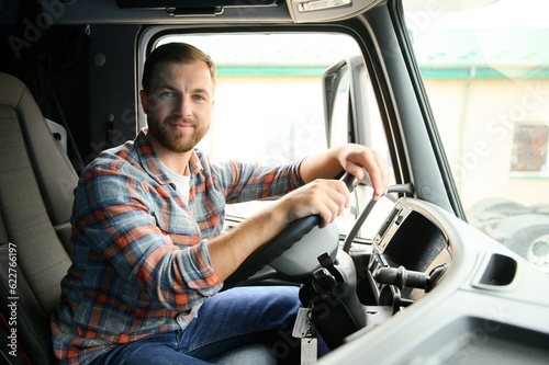 Side view of professional driver behind the wheel in truck's cabin.