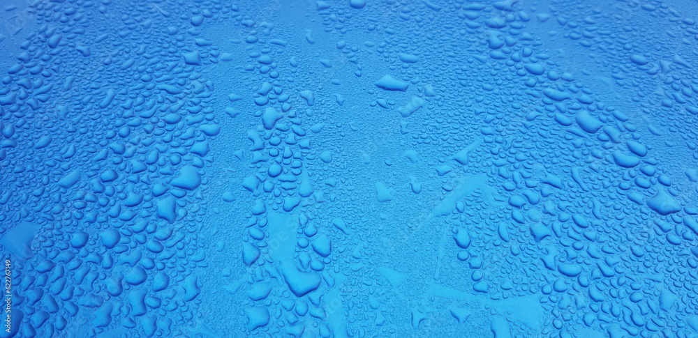 Water beads off a blue car bonnet Water beads off a blue car bonnet