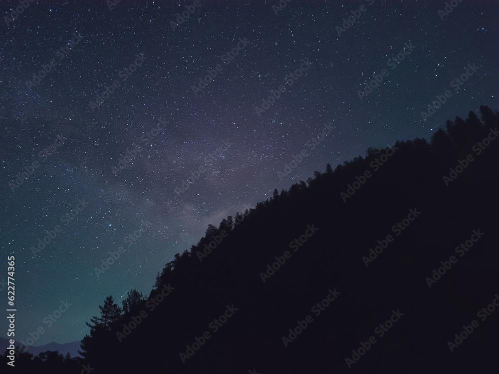 The Milky Way galaxy rises above the mountains.