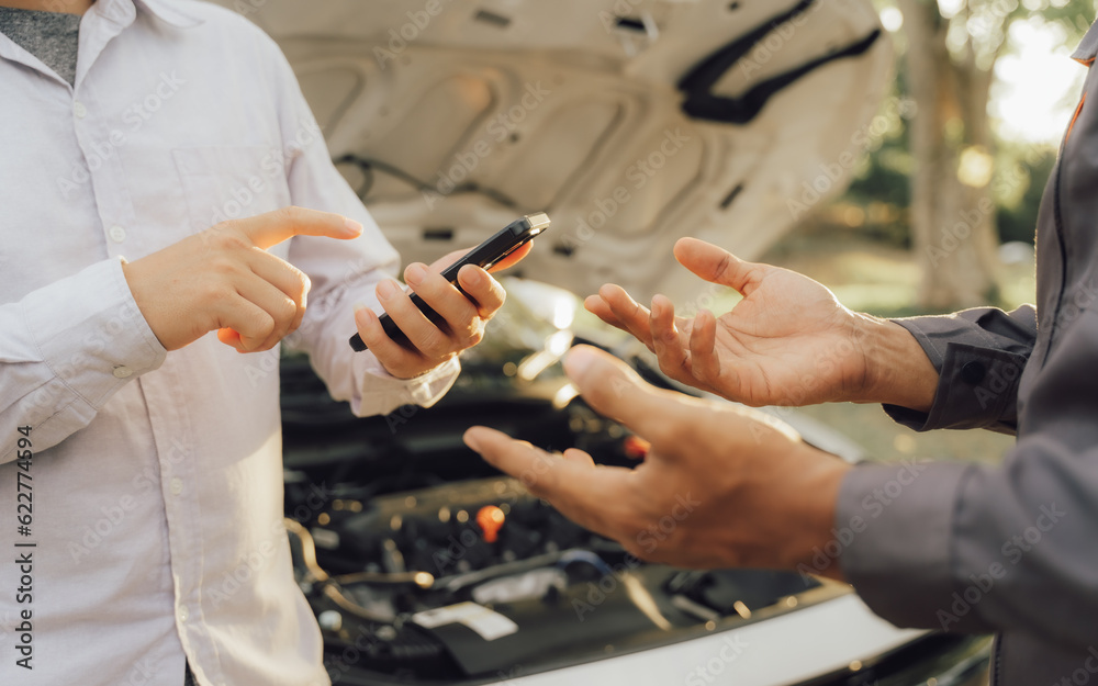 Young mechanic opens the bonnet to inspect the engine for damage and does professional maintenance. He puts on his uniform and inspects. Young mechanic opens the bonnet to inspect the engine for damage and does professional maintenance. He puts on his uniform and inspects.