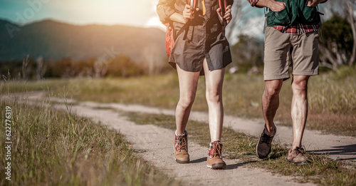 Adventure, travel, tourism, hiker and backpack Concept. Hikers with backpacks walking trough forest path wearing mountain boots with focus on shoes.