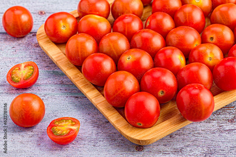 Natural flavors: cherry tomatoes on elegant wooden tray Natural flavors: cherry tomatoes on elegant wooden tray
