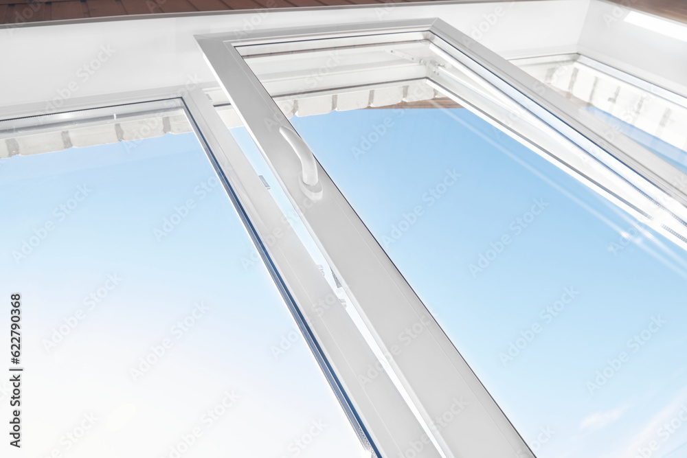 Fototapeta premium Opened plastic window frame for ventilation. PVC window. Tilted pvc window frame. Bottom view. Room ventilation.